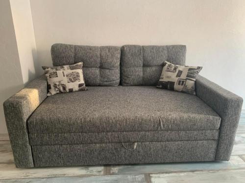 un divano grigio in una stanza con cuscini sopra di Квартира в новострое a Odessa