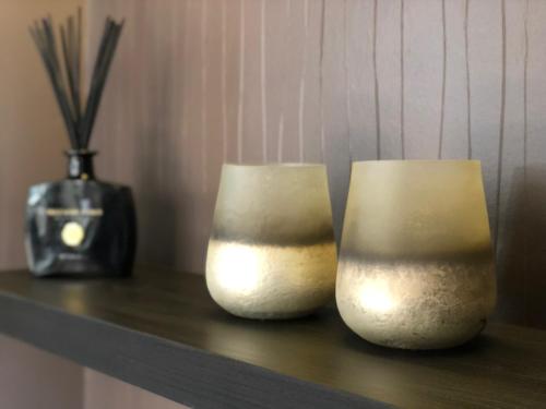 two white vases sitting on a shelf with a vase at Margaréta Garden & SPA in Eger