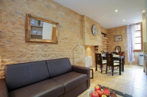 a living room with a couch and a dining room at Le Grenier du Chapitre in Sarlat-la-Canéda
