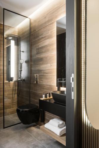 a bathroom with a black toilet and a sink at LUX&EASY Athens Downtown Apartments in Athens