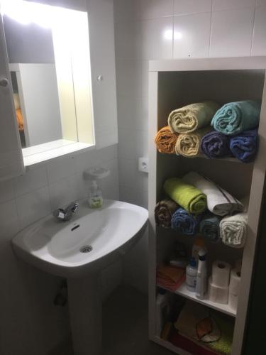 a bathroom with a sink and a mirror and towels at Casa Angeles in Santa Cruz de la Palma