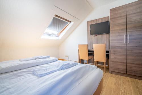 a bedroom with two beds and a desk with a tv at Mühlengarten by Relax Inn - Staffless & Self Check-In in Nittel