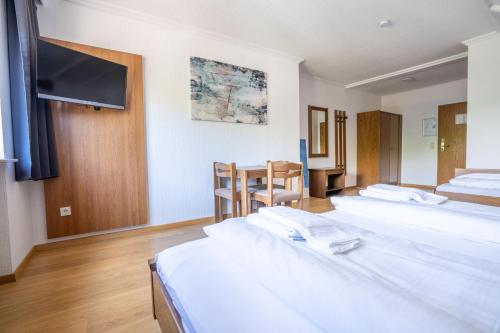 a hotel room with a bed and a desk at Mühlengarten by Relax Inn - Fully Digital & Self Check-In in Nittel