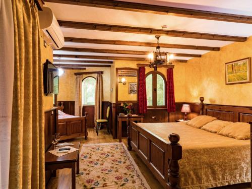 a bedroom with a bed and a desk and a couch at Hotel Castle Park in Berat