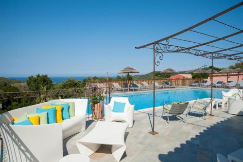 vistas a una piscina con sillas blancas y a una piscina en Domaine de Sonia - Logements éco-insolites, en Porto Vecchio