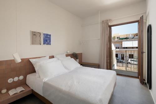 卡尼亞鎮的住宿－Lofos Casteli Sunlight，卧室设有白色的床和大窗户