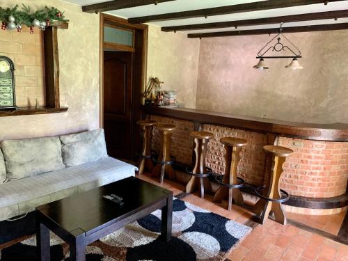 eine Bar mit Bank und Hockern in einem Raum in der Unterkunft Vila Darija Zlatar - LUX apartman br. 5 in Nova Varoš
