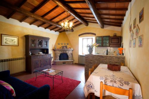 sala de estar con mesa y chimenea en Agriturismo Podere Poggiarone, en Rapolano Terme