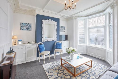 a living room with blue walls and a table and chairs at Host & Stay - The Gallery Apartments in Scarborough