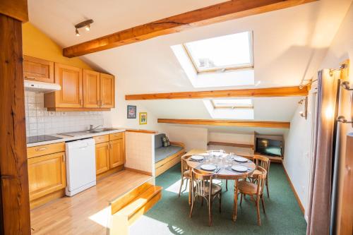 une cuisine et une salle à manger avec une table et des chaises dans l'établissement cellier 8 appart 5 personnes les 2 alpes, à Les Deux Alpes