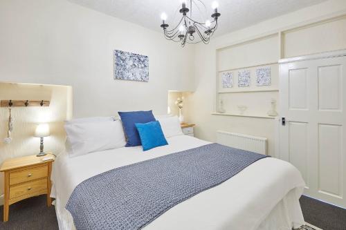 Host & Stay - The Gallery Apartments في سكرابورو: غرفة نوم مع سرير أبيض كبير مع وسائد زرقاء