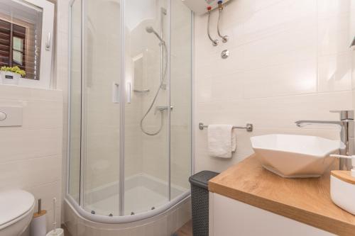 een badkamer met een douche en een wastafel bij Villa Vitis in Oklaj