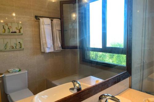 une salle de bain avec un lavabo et un miroir et des toilettes dans l'établissement Apartamento Familiar con vistas *****, à Baiona