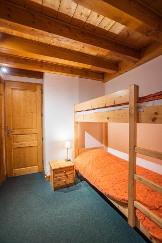 une chambre avec deux lits superposés et une table dans l'établissement cellier 8 appart 5 personnes les 2 alpes, à Les Deux Alpes