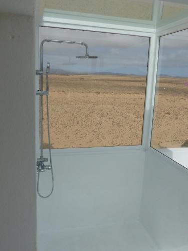 a shower in a room with a view of the desert at Lanzarotearena in Tinajo