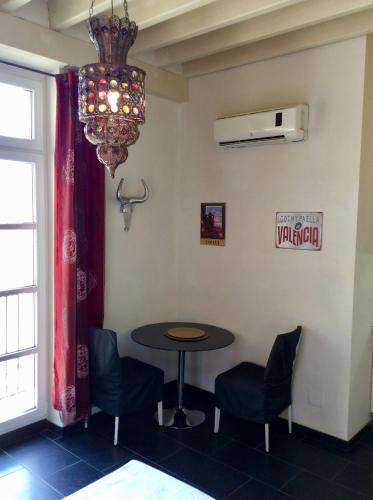 a table and chairs in a room with a chandelier at Santa Barbara Guesthouse in Alicante