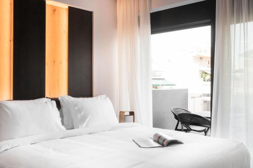 a bedroom with a white bed and a window at LUX&EASY Athens Downtown Apartments in Athens