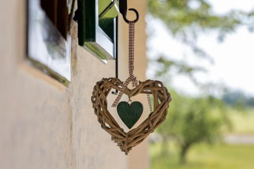 a wooden heart hanging from a window at Kellerstöckl Gaaserberg in Gaas