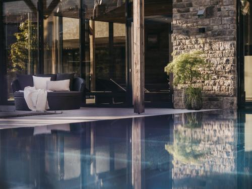 a couch sitting next to a swimming pool at VAYA Fieberbrunn inklusive Gästekarte in Fieberbrunn