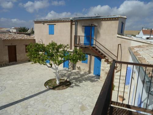 a house with blue doors and a tree in a courtyard at To Archontiko tis Anastasias in Athienou