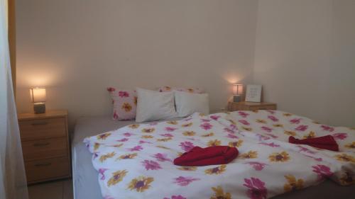 a bed with a white comforter with flowers on it at GRAN hostel in Banská Bystrica