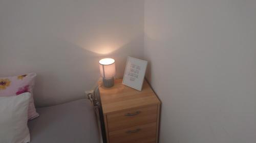 a nightstand with a lamp on it next to a bed at GRAN hostel in Banská Bystrica