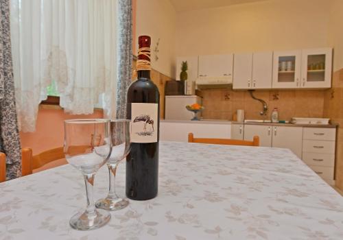 eine Flasche Wein und zwei Weingläser auf dem Tisch in der Unterkunft Apartments Ella in Poreč