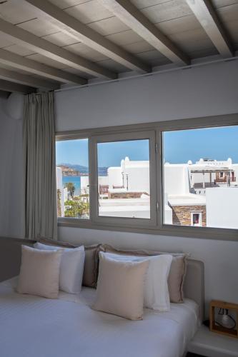 a white couch with pillows in front of a window at Argo Boutique Hotel in Naxos Chora