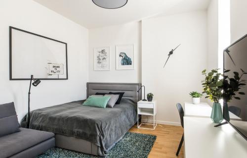a bedroom with a bed and a couch at Cozy Modern Studio in City Centre & QueenSize Bed in Rīga
