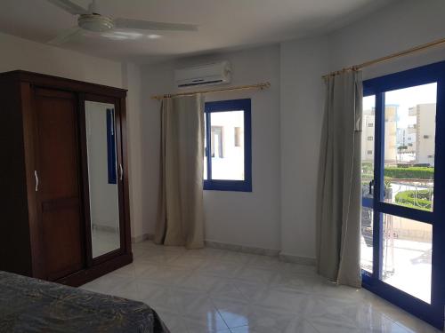 a bedroom with a bed and sliding glass doors at Golden Beach 1 for family in Ras Sedr