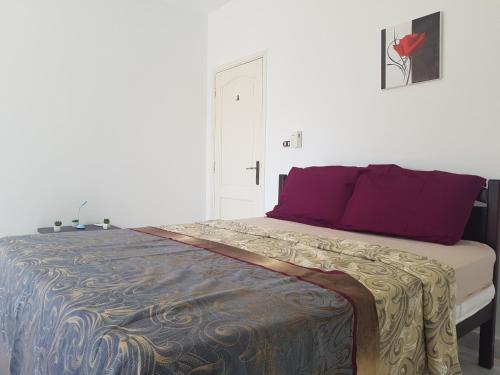 a bedroom with a large bed with purple pillows at Golden Beach 1 for family in Ras Sedr