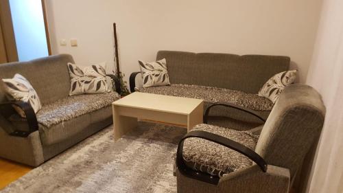 a living room with two couches and a coffee table at Redon Apartment in Pristina