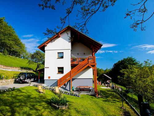 ein weißes Gebäude mit einem Holzdach in der Unterkunft Willa Pod Bukami in Wisła