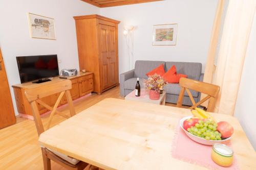 a living room with a table with a bowl of fruit on it at Appartements Bernhofer in Saalbach Hinterglemm