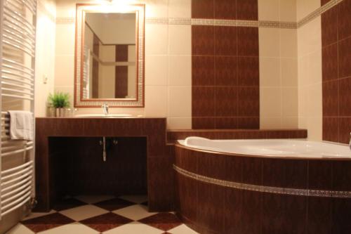 a bathroom with a tub and a sink and a mirror at Penzion U Císaře Zikmunda in Znojmo