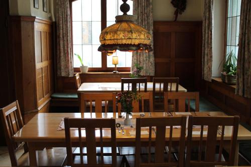 a dining room with a table and chairs and a chandelier at Hotel Gasthof zur Linde in Rothenburg ob der Tauber
