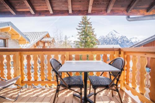 een tafel en stoelen op een terras met besneeuwde bergen bij cellier 6 in Les Deux Alpes