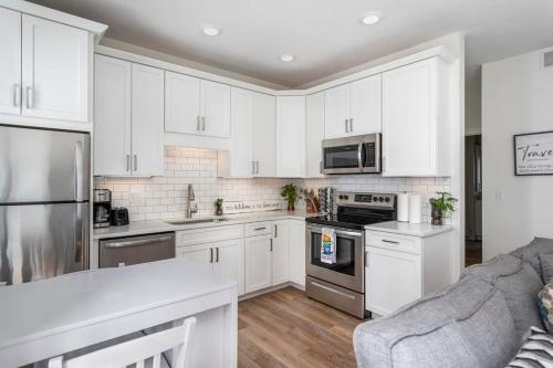 a kitchen with white cabinets and stainless steel appliances at Capri 106 in the Heart of Downtown Traverse City in Traverse City