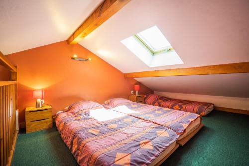 a attic bedroom with a bed and a window at cellier 6 in Les Deux Alpes