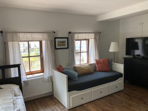 a bed in a room with two windows at Apartmány Rožmberk in Rožmberk nad Vltavou