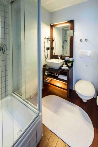 ein Badezimmer mit Dusche, Toilette und Waschbecken in der Unterkunft Hotel Concorde in Frankfurt am Main