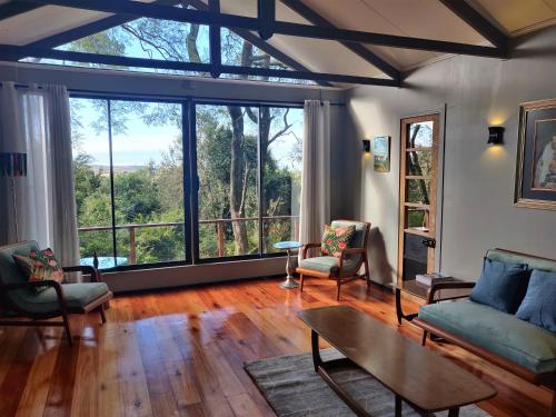 a living room with a couch and chairs and a table at Karkloof Hideout in Howick