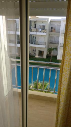 a view of a balcony from a room with a window at Casabay Appart Vue Sur Piscine in Sidi Rahal
