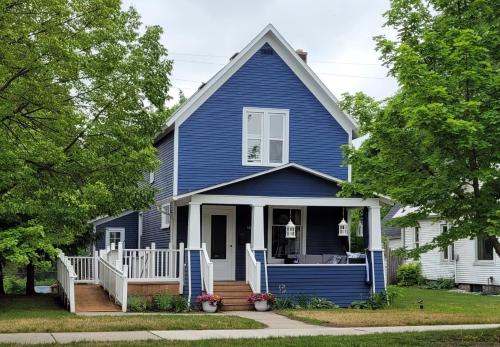 a blue house with a front porch and stairs at The Blue House on Front Downtown Traverse City in Traverse City