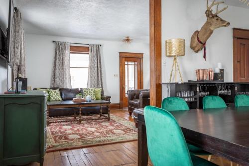 a living room with a table and green chairs at The Blue House on Front Downtown Traverse City in Traverse City
