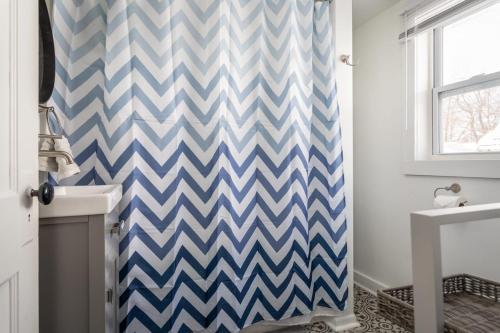 a bathroom with a blue and white chevron shower curtain at The Blue House on Front Downtown Traverse City in Traverse City