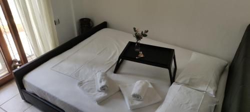 a bed with a nightstand and two towels on it at Maria's Luxury Apartment in Kassandria