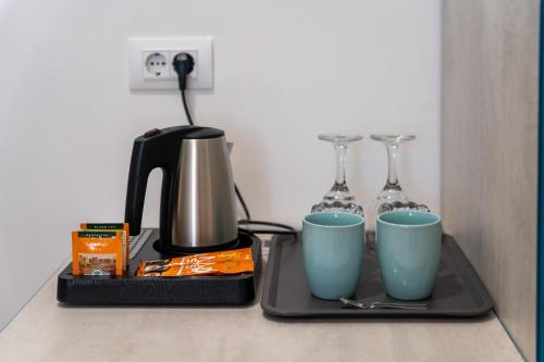 a tray with a coffee maker and two cups on a counter at Polesana Rooms in Pula