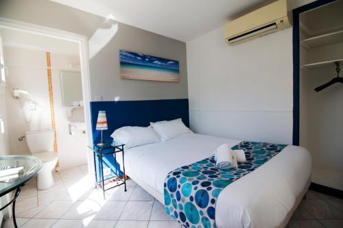 a bedroom with a bed and a glass table at Hôtel Bel Azur in Six-Fours-les-Plages