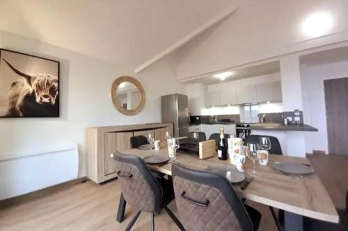 une table à manger avec des chaises et une photo d'une vache dans l'établissement L'Izar - Chalet des Etoiles - La Mongie, à Bagnères-de-Bigorre